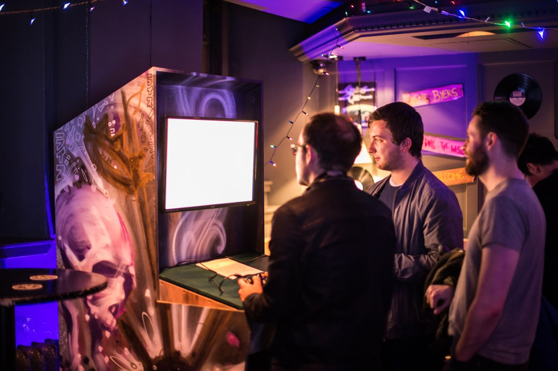 People at last year’s GamesAreForEveryone gathered around a hybrid arcade cabinet.